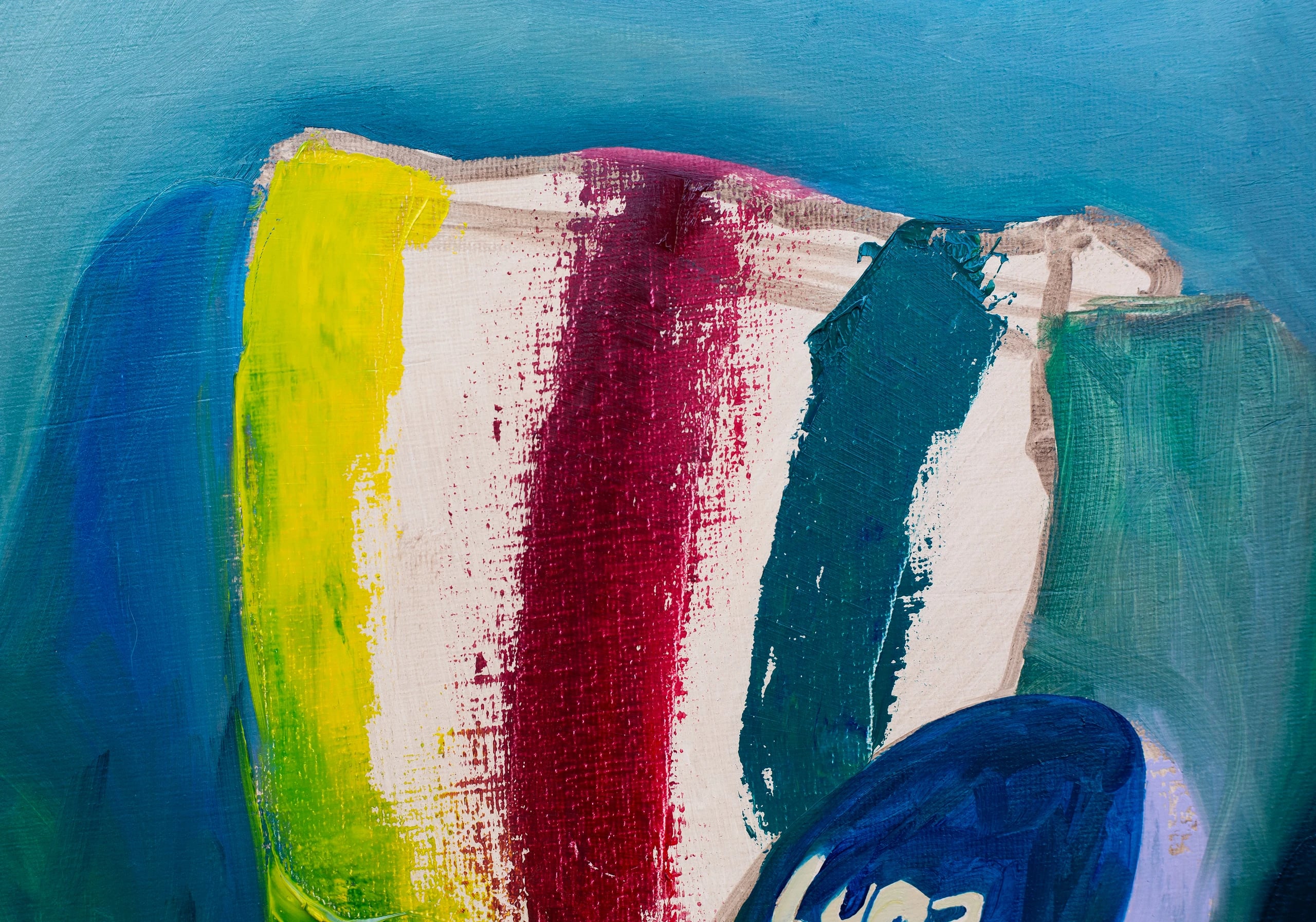 Close-up of the striped blanket in yellow, white, crimson and teal over the green armchair.